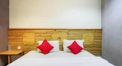 a bedroom with a bed with two red pillows at OYO 89454 Hotel Pavilion Inn in Ayer Tawar
