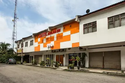 an orange and white building on a street at OYO 89454 Hotel Pavilion Inn in Ayer Tawar