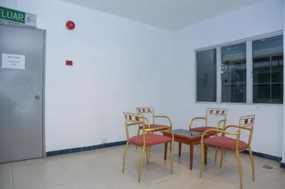 a group of chairs and a table in a room at Capital O 89876 Safari Hotel in Pasir Bogak