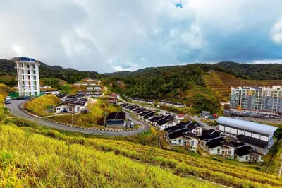 a small town on a hill with a road and buildings at The Hotel Tudor Inn in Brinchang