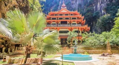 an orange building with a palm tree in front of it at OYO 90936 Hotel Manjoi Inn Ipoh in Jelapang