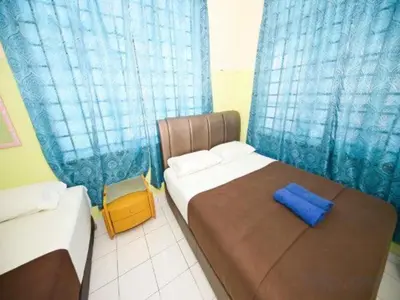 a bedroom with a bed with a blue curtain at Hotel O Iman Roomstay Gua Musang in Kampong Keriting