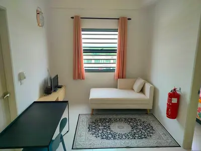 a living room with a chair and a table and a window at IFS SoHo Basic Homestay Entire Home in Seri Iskandar