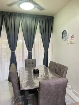 a dining room with a table and chairs and curtains at Imtiyaz Islamic Homestay in Kulim