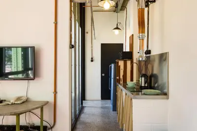 a kitchen with a counter and a tv on a wall at Belakang Kong Heng Ipoh Hotel in Ipoh