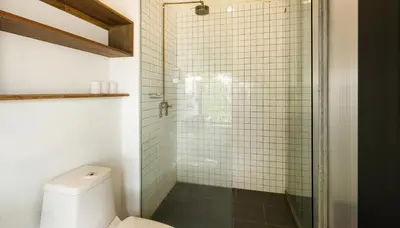 a bathroom with a glass shower with a toilet at Belakang Kong Heng Ipoh Hotel in Ipoh