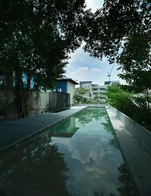 a pool of water in a yard with trees at Belakang Kong Heng Ipoh Hotel in Ipoh