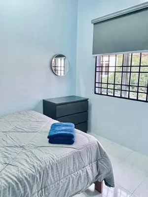 a bedroom with a bed and a dresser and a mirror at D Ocean Homestay in Seri Manjung