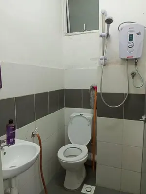 a bathroom with a toilet and a sink at Apartment Cameron Jaya in Tanah Rata