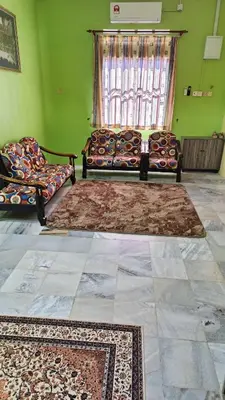 a living room with two couches and a window at Homestay Kak Rose Kuala Lipis in Kuala Lipis
