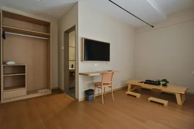 a living room with a desk and a tv on a wall at Simple Sanctuary Tanjung Tokong in Tanjung Bungah