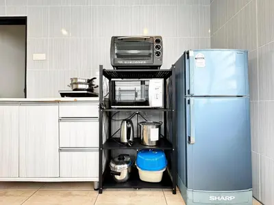 a kitchen with a refrigerator and a microwave on a shelf at i Homes Villa 2 at Ipoh Town 16 Guest in Ipoh