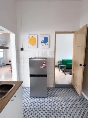 a kitchen with a refrigerator in the middle of a room at Canning 48 in Ipoh