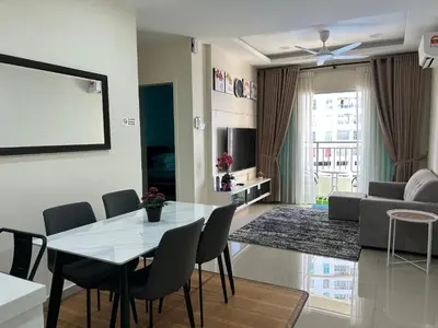 a dining room and living room with a table and chairs at Hazel Luxe Apartment in Permatang Pauh