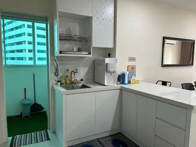 a white kitchen with a sink and a microwave at Hazel Luxe Apartment in Permatang Pauh