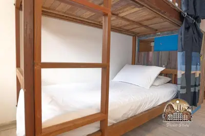 a bedroom with a bunk bed with white sheets at Parlor Hotel in Ipoh