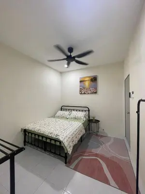 a bedroom with a bed and a ceiling fan at mOmma's Homestay in Seri Iskandar