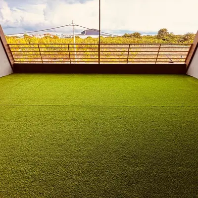 a balcony with green grass and a fence at Mia homestay in Teluk Intan