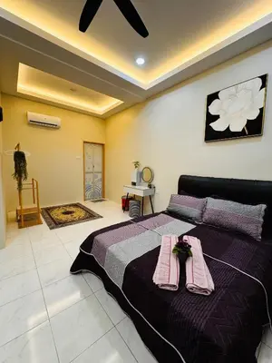 a bedroom with a large bed with two towels on it at Mia homestay in Teluk Intan