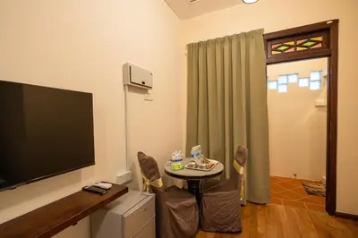 a living room with a table and a flat screen tv at LINN House Peranakan Residence George Town in George Town