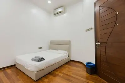 a bedroom with a white bed and a wooden floor at Gelugor 2Storey Big Bungalow 23pax with BBQ Snooker in Gelugor