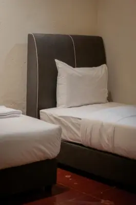 a bed with a headboard and a pillow on it at Melayu Villa by Aayu - 8 mins walk to Armenian St in George Town