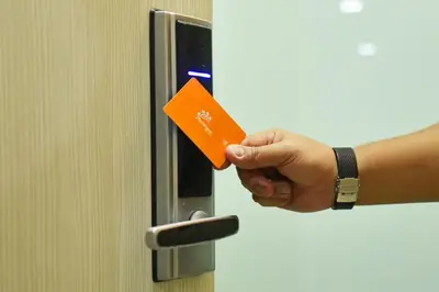 a person holding an orange credit card in a door at Hotel Mornington Bukit Permata Lumut in Lumut