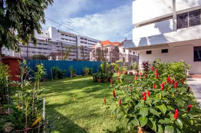 a garden with red flowers in a yard at Bahagia Stay Georgetown in George Town