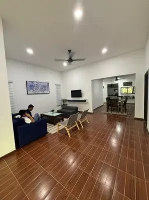a man sitting on a couch in a living room at Bagan Serai Simpang Empat Parit Buntar Perak by 3SIBS in Bagan Serai