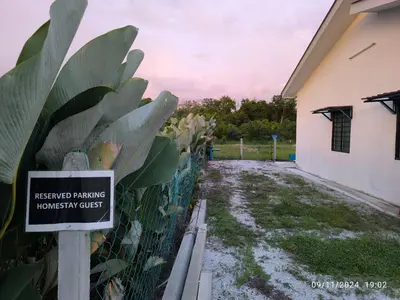 a sign on a fence in front of a house at a&h homestay in Teluk Intan