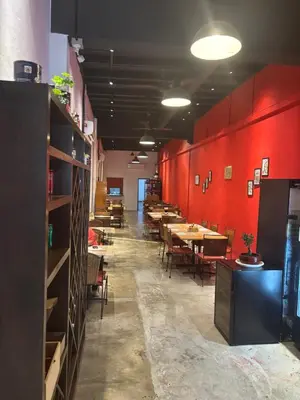 a dining room with tables and chairs and red walls at Victoria Pods in George Town