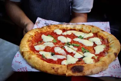 a pizza sitting on top of a paper at Victoria Pods in George Town