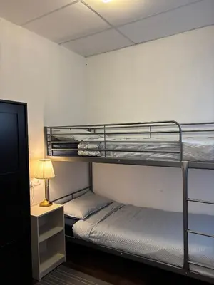 two bunk beds in a room with a lamp at Victoria Pods in George Town