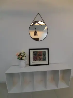 a white shelf with a mirror on a wall at Crystal Heights Cozy House in Tupai