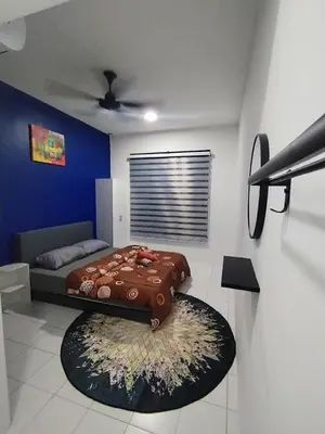 a bedroom with a bed and a blue wall at MyPutra Homestay Parit Buntar in Parit Buntar