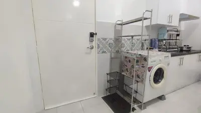 a white kitchen with a washing machine in a room at Sweet Home Ipoh in Ipoh