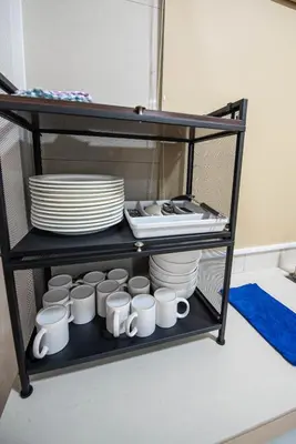 a shelf with plates and cups and plates on it at De Luma TheRumah 5 bedroom 3 bathroom in Bukit Mertajam