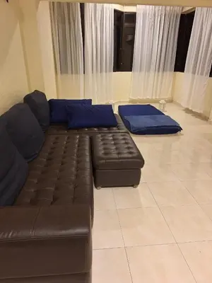a living room with a leather couch and blue pillows at Seaput Homes in Ayer Itam