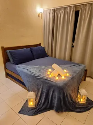 a bedroom with a bed with candles on it at Seaput Homes in Ayer Itam