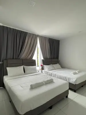 two beds sitting in a room with a window at TDOZE Hotel in Brinchang
