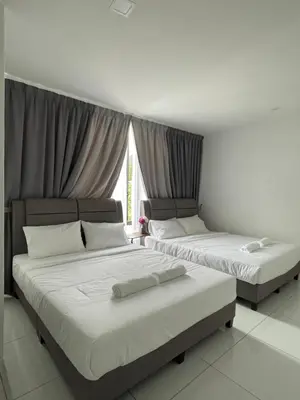 two beds sitting in a room with a window at TDOZE Hotel in Brinchang