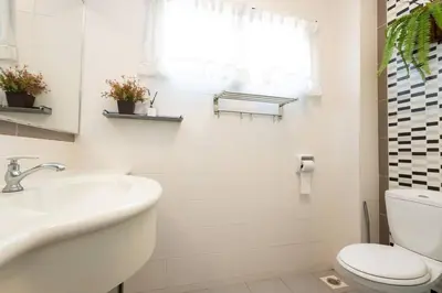 a white bathroom with a toilet and a sink at Retro Homestay Ipoh - Semi D 15pax Wedding in Ipoh
