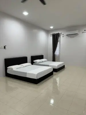 two beds in a room with white walls at Homestay Kakak Adek 3 in Parit Buntar