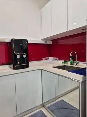 a kitchen with white cabinets and a black appliance on the counter at Modern & Relax Studio Penang in George Town