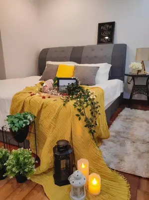 a bed with a table with a yellow blanket and candles at NEW! Spacious 3BR Luxury Stay at Sunrise Gurney GeorgeTown in George Town