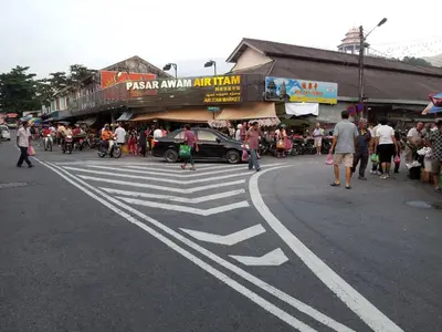 a group of people walking on a street with a crosswalk at Stylish&Affordable Serenity Suite #2min KekLokSi in Ayer Itam