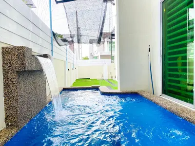 a pool with a waterfall in the middle of a building at D'villa Aryan homestay with private pool in Sungai Petani