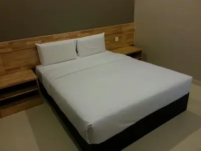 a bed with white sheets and pillows in a room at JQ Suria 18 Hotel in Ipoh