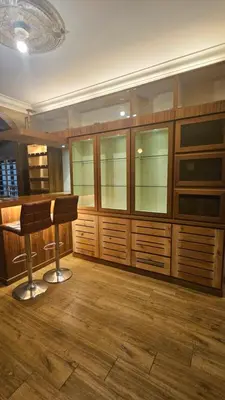 a bar with wooden cabinets and a stool in a room at Mount Lake Villa in Ipoh