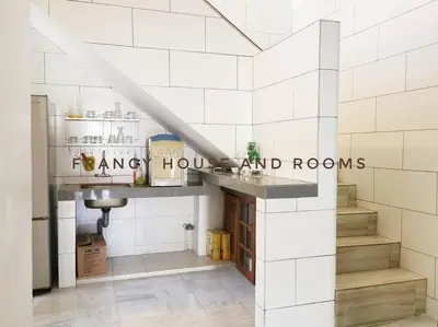 a kitchen with white tiled walls and a counter at Semi-D Landed House Bercham Ipoh in Ipoh
